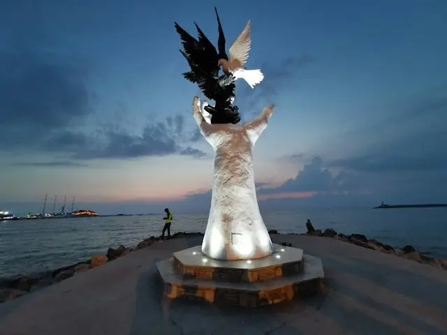 A statute of a hand holds pigeons in Kusadasi