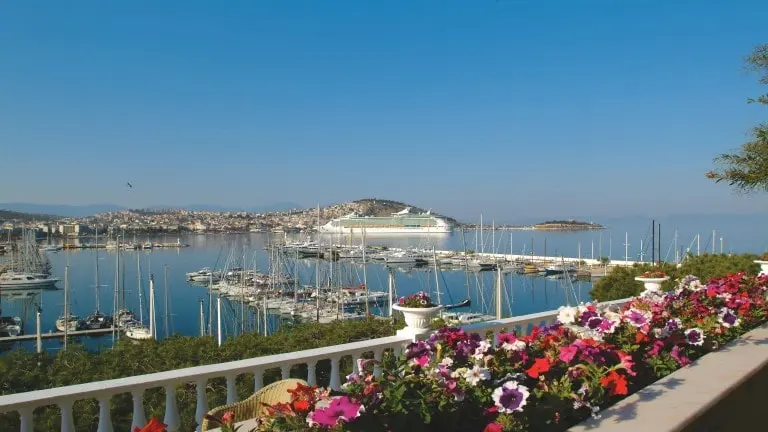 A large cruise ship docks at Kusadasi Port at the view of Kusadasi Bay