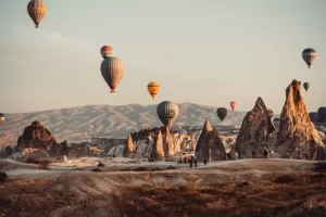 2 Day Cappadocia Tour From Istanbul Cappadocia Balloon ascending over fairy chimneys and some people watching them.